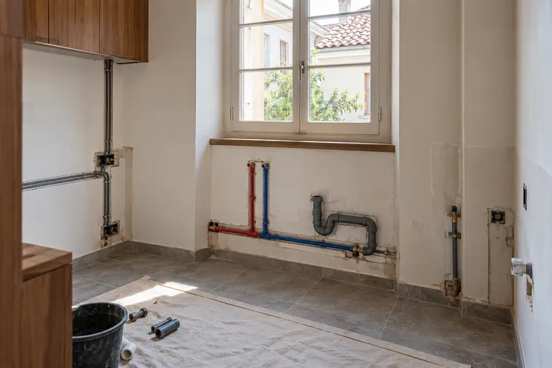 Visualización conceptual IA: Tuberías de suministro y desagüe durante la renovación de una cocina.